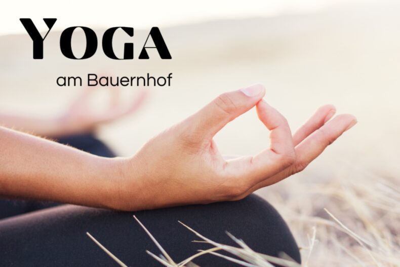 Das Bild zeigt eine entspannte Yoga-Szene in natürlicher Umgebung. Im Fokus steht eine Hand in der klassischen Gyan-Mudra-Haltung – Daumen und Zeigefinger berühren sich sanft. Der Text "Yoga am Bauernhof" steht links oben im Bild.