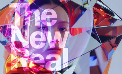 Alt-Text: Ein Porträt einer Person mit futuristischer Ästhetik, umgeben von reflektierenden, prismatischen Flächen und leuchtenden Farben. Darüber liegt der Schriftzug „The New Real“ in großen, halbtransparenten Buchstaben.