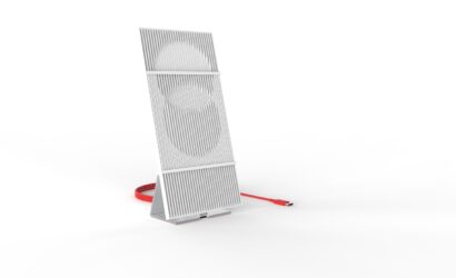 Ein modernes, aufrecht stehendes elektronisches Gerät mit vertikalen Lamellen und einem rot sichtbaren USB-C-Kabel. Das Design ist minimalistisch, weiß-grau mit einer Struktur, die kreisförmige Formen hinter den Lamellen andeutet.